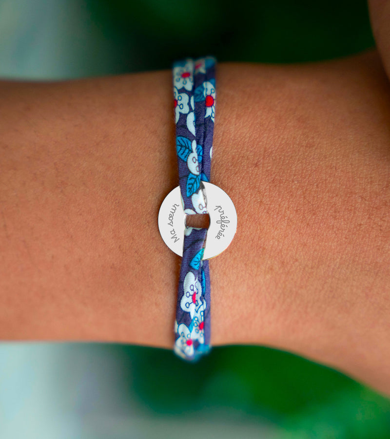 Le bracelet en cible, orné d'une médaille de 15mm en argent personnalisé, est délicatement rehaussé par un lien Liberty Iris.
