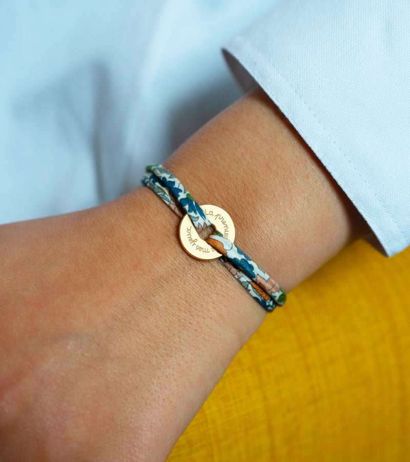 Lié par le liberty lilas, ce bracelet personnalisé en forme de cible est plaqué or 15mm.