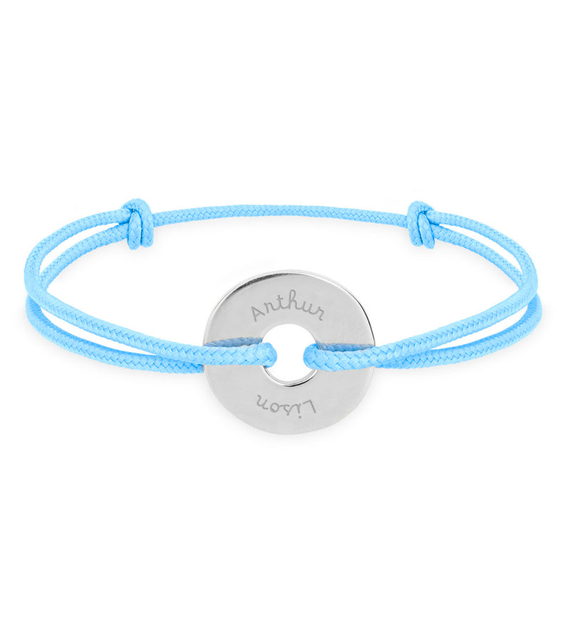 Arborant un cordon bleu pastel, ce bracelet en forme de cible est personnalisé de 15mm en argent.
