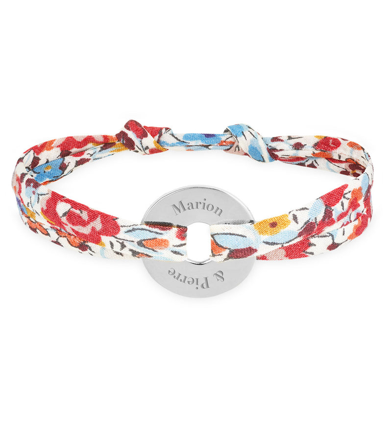 Un bracelet en forme de cible, personnalisé de 15mm en argent, lié par le liberty pavot.