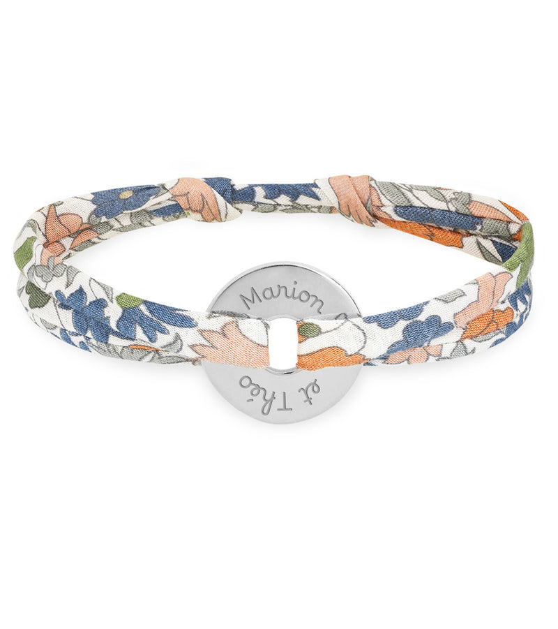 Un bracelet en forme de cible, relié par un liberty lilas, personnalisé de 15mm en argent.