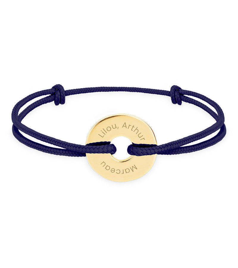 un bracelet de forme cible, personnalisé en 15mm et plaqué or, agrémenté d'un cordon bleu marine.