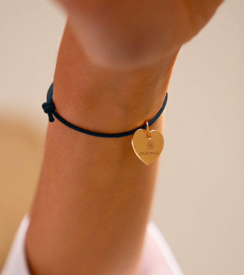 Un bracelet bleu marine agrémenté d'un cœur en plaqué or de 15mm.