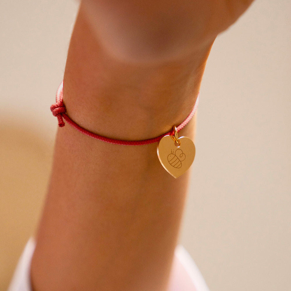 Bracelet en cordon rouge orné d'un charmant cœur plaqué or de 15mm.