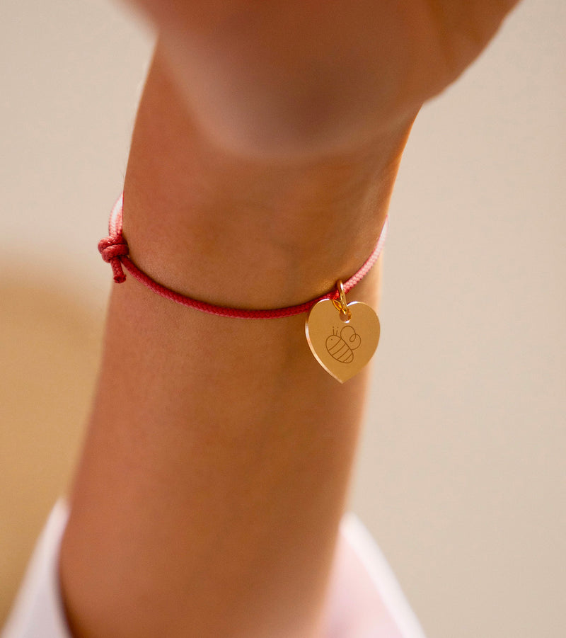 Bracelet en cordon rouge orné d'un charmant cœur plaqué or de 15mm.