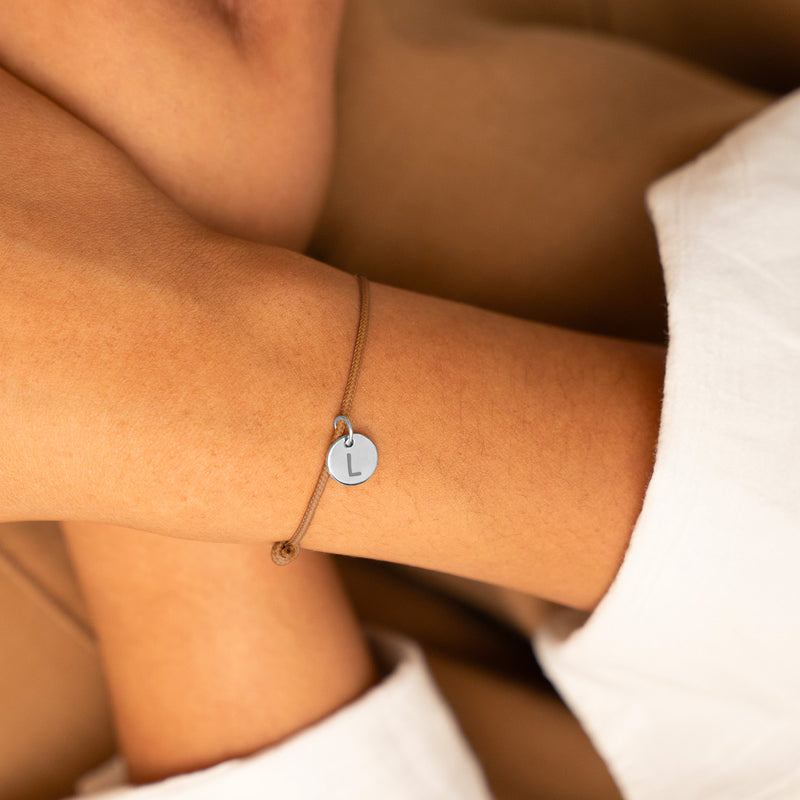 Bracelet en argent avec médaille personnalisée de 10mm, sur un cordon marron clair, pour une touche de sophistication à votre tenue.