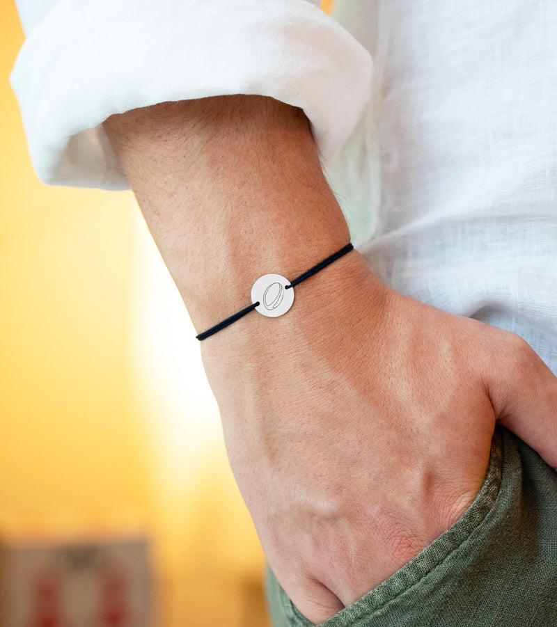  un bracelet en argent de 15mm avec une médaille personnalisée, attachée à un cordon noir doté de deux trous.