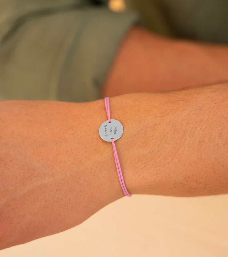 Un bracelet argenté éclatant, mis en valeur par une médaille de 15mm personnalisée avec 2 trous, accompagné d'un cordon rose raffiné.
