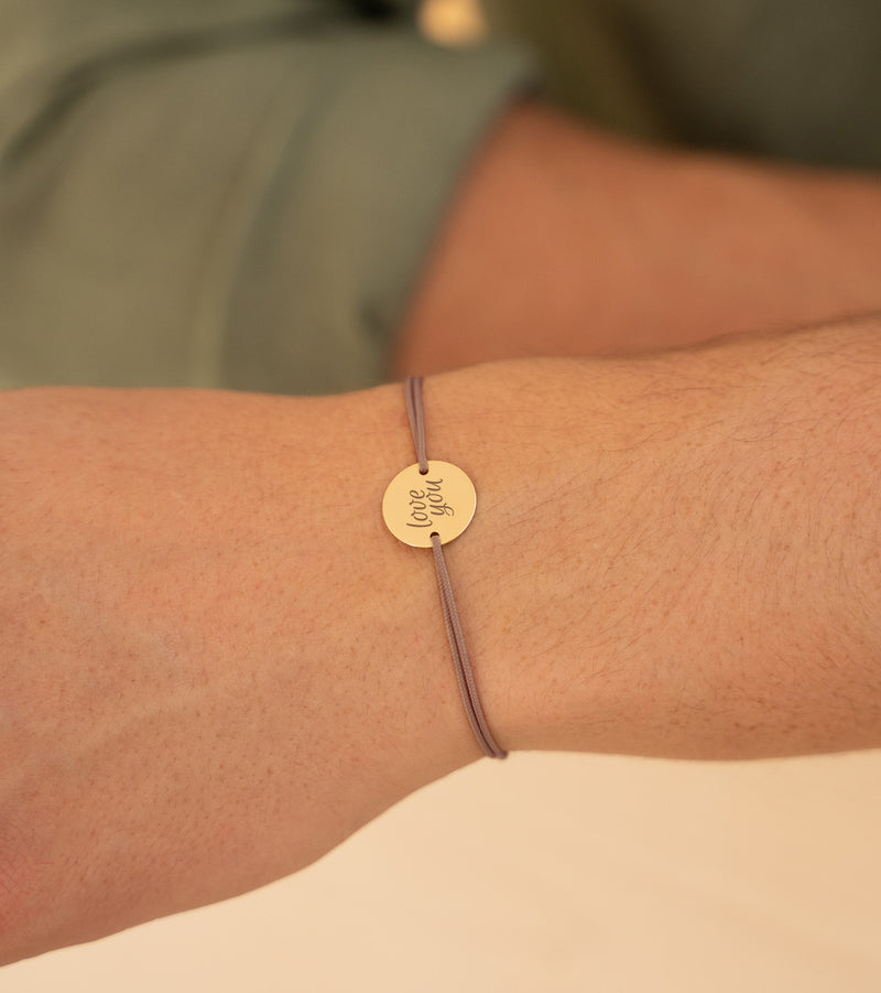 bracelet personnalisé doté d'une médaille de 15mm plaquée or, de deux trous, fixée à un cordon marron clair.