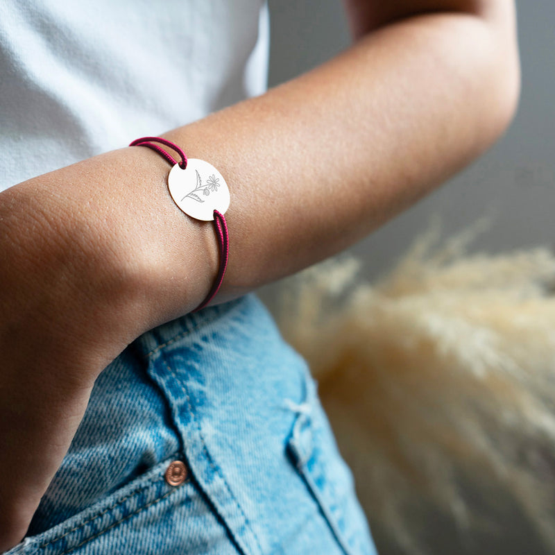Un bracelet médaille en 20mm, personnalisé à votre goût, intégrant deux trous en plaqué argent, accompagné d'un cordon rose fushia.