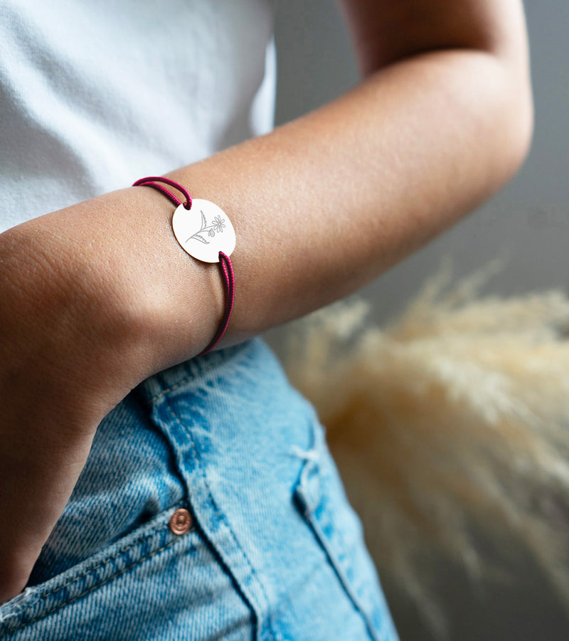 Un bracelet médaille en 20mm, personnalisé à votre goût, intégrant deux trous en plaqué argent, accompagné d'un cordon rose fushia.