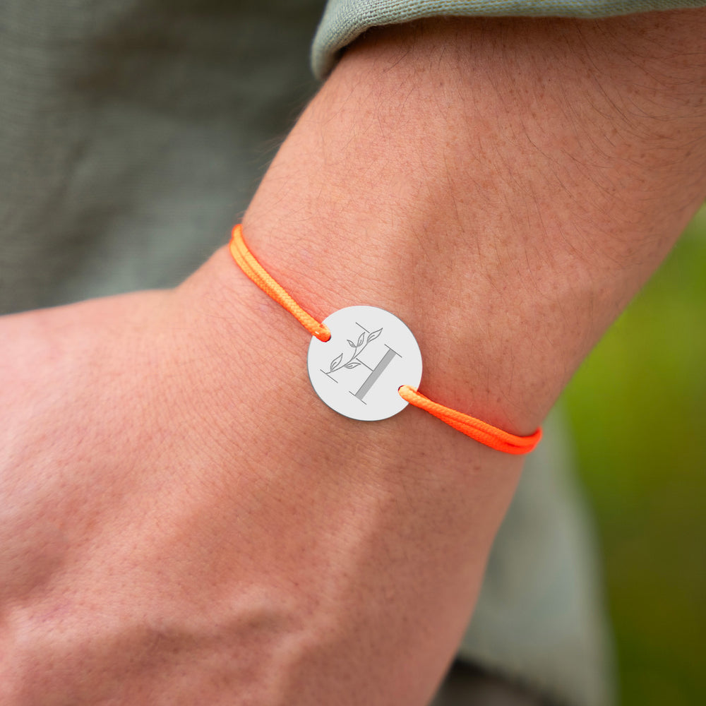 Orné d'une médaille, personnalisée 20mm, ce bracelet arbore deux trous argent et un cordon orange fluo.