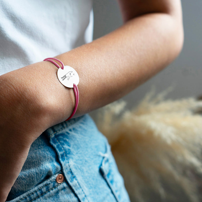 Paré d'une médaille personnalisée de 20mm, ce bracelet présente deux trous argent et un cordon rose distinctif.