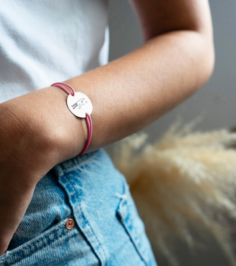 Paré d'une médaille personnalisée de 20mm, ce bracelet présente deux trous argent et un cordon rose distinctif.