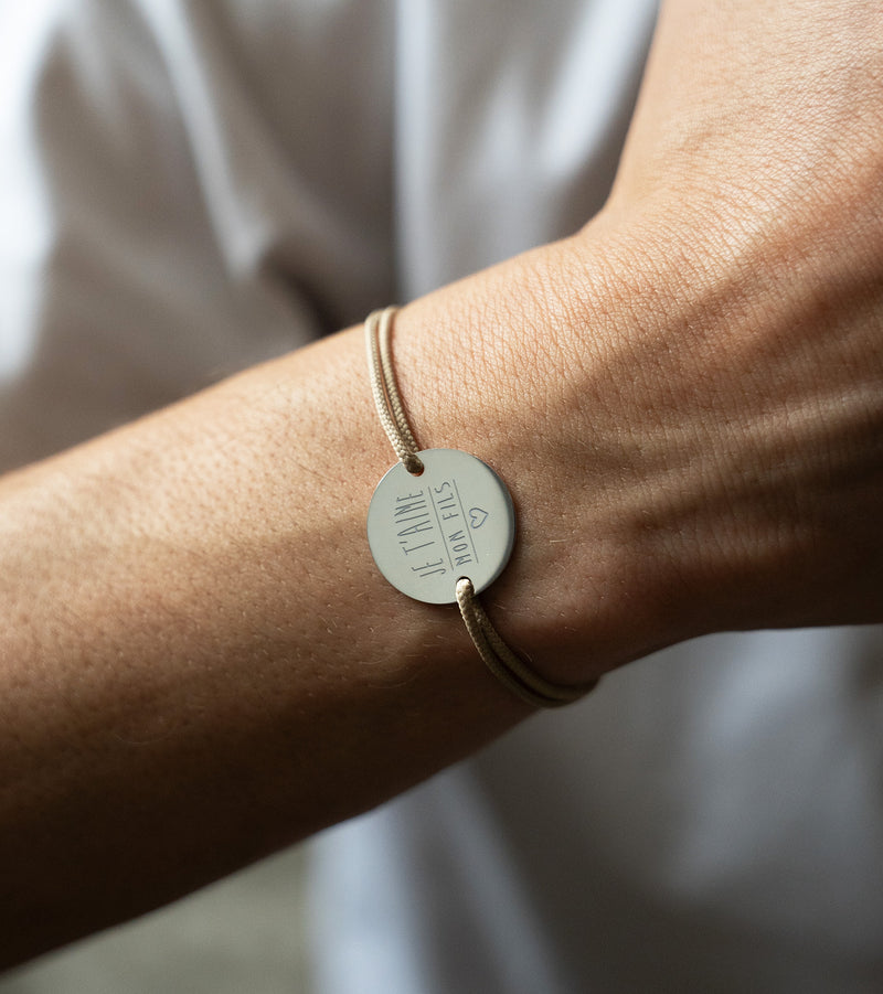 bracelet médaille en 20mm présente deux trous en plaqué argent et un cordon marron clair.
