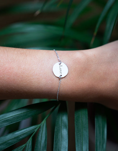 Un bracelet en argent brillant, doté d'une chaîne délicate et d'une médaille personnalisée de 15mm à deux trous. 