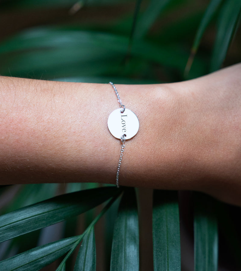 Un bracelet en argent brillant, doté d'une chaîne délicate et d'une médaille personnalisée de 15mm à deux trous. 