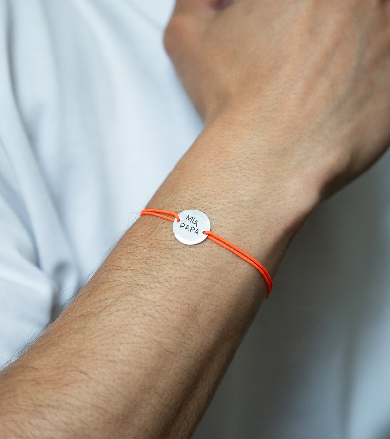 Un bracelet argenté de 15mm, avec deux trous distinctifs pour un cordon orange fluo.