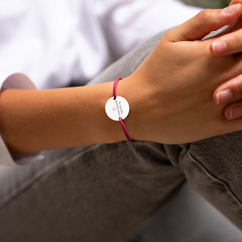 Bracelet médaille personnalisé en 20mm, doté de deux trous en plaqué argent, et complété par un cordon rose fushia.