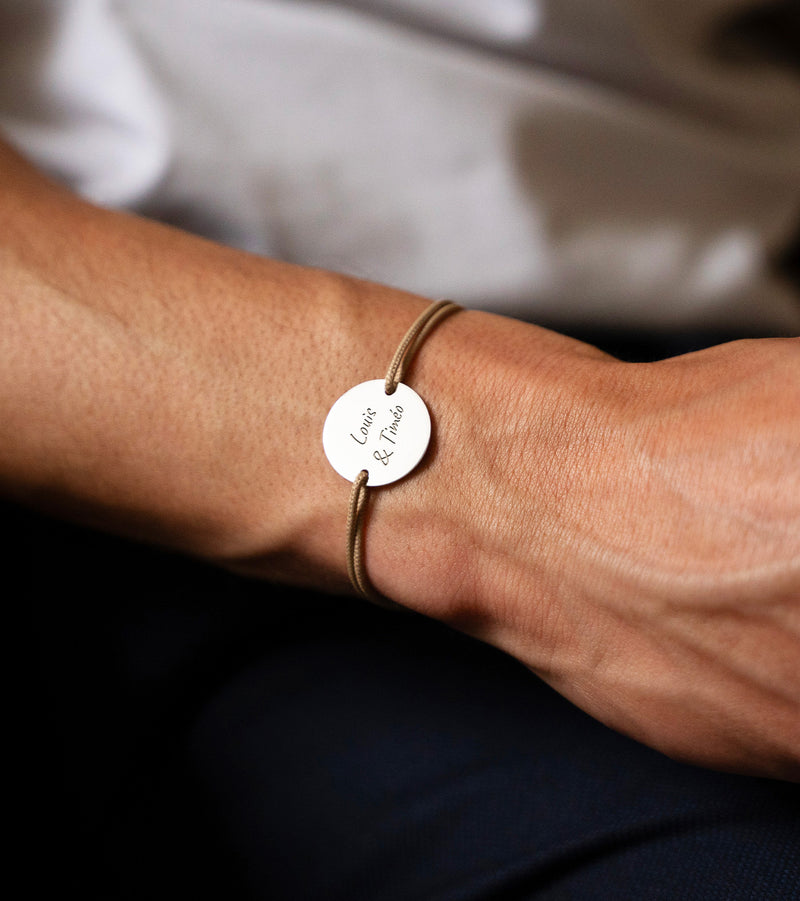 Un bracelet unique, médaille argentée 20mm, personnalisé, avec cordon beige et deux trous.