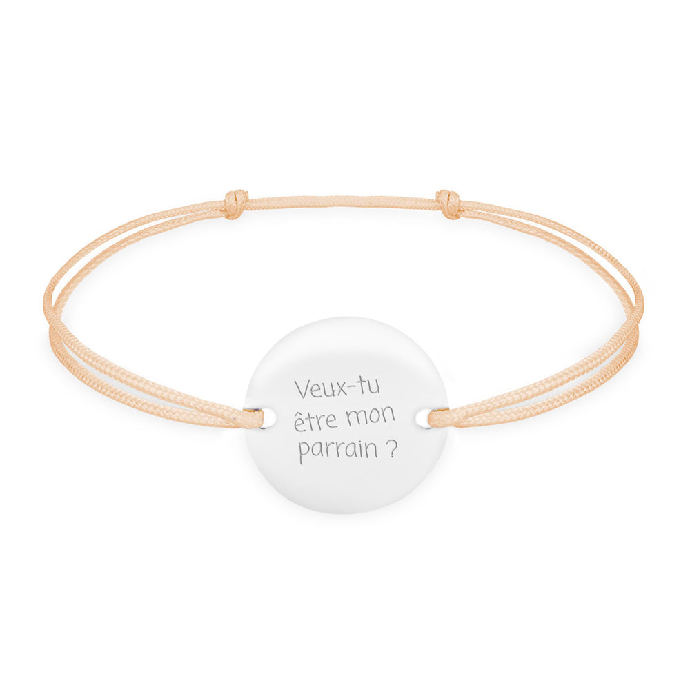 Un bracelet en argent orné d'une médaille personnalisée de 15mm, doté de deux trous pour un cordon beige.