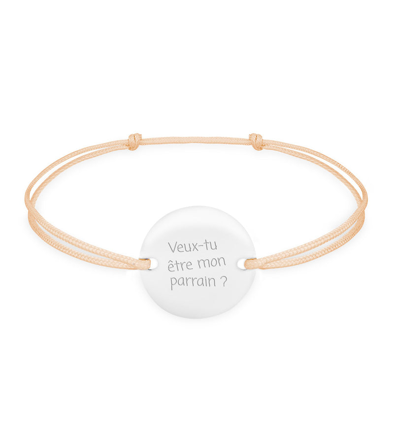 Un bracelet en argent orné d'une médaille personnalisée de 15mm, doté de deux trous pour un cordon beige.