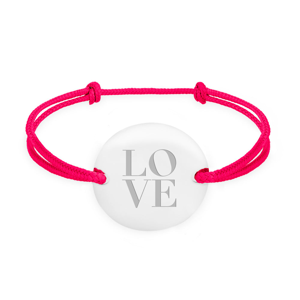 Un bracelet médaille, personnalisé en 20mm, avec deux trous en plaqué argent, rehaussé d'un cordon rose fushia.