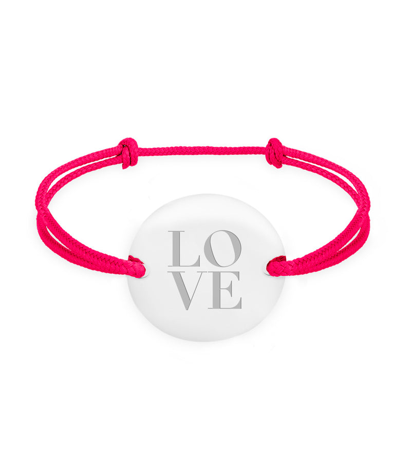 Un bracelet médaille, personnalisé en 20mm, avec deux trous en plaqué argent, rehaussé d'un cordon rose fushia.