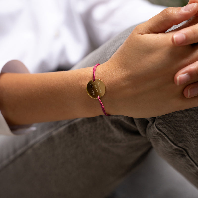 Personnalisez votre style avec ce bracelet médaille en 20mm, orné de deux trous en plaqué or et d'un cordon rose fuchsia.