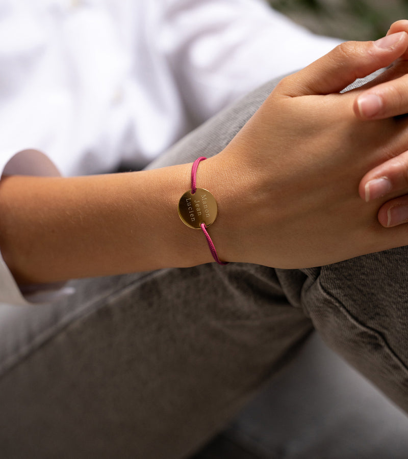 Personnalisez votre style avec ce bracelet médaille en 20mm, orné de deux trous en plaqué or et d'un cordon rose fuchsia.
