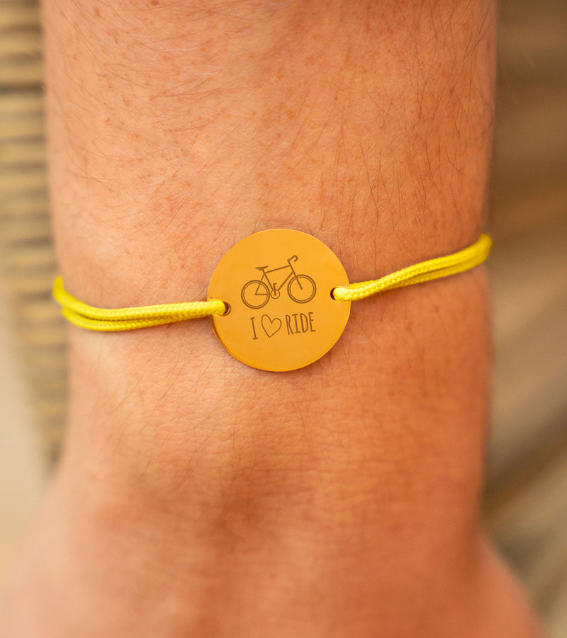 Le bracelet parfait pour les amateurs de vélo ! Médaille plaqué or, cordon jaune : personnalisez-le pour porter vos passions et vos souvenirs à votre poignet.