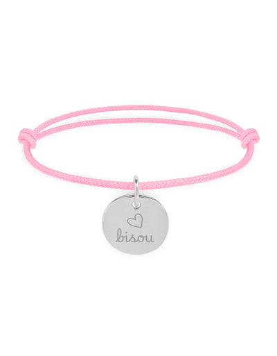 Un bracelet argenté avec une médaille de 15mm et un cordon rose.