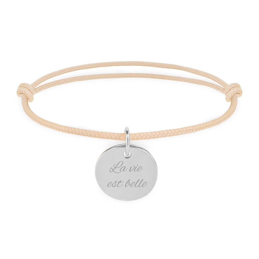 Bracelet en argent, agrémenté d'une médaille de 15mm, personnalisée, et d'un cordon beige.
