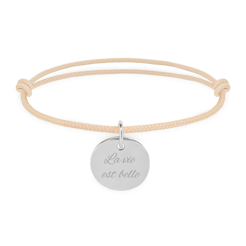 Bracelet en argent, agrémenté d'une médaille de 15mm, personnalisée, et d'un cordon beige.