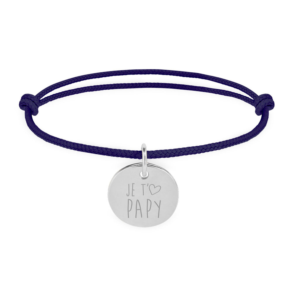 Un bracelet en argent avec une médaille de 15mm, portant un cordon bleu marine.