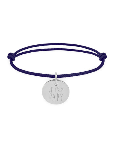 Un bracelet en argent avec une médaille de 15mm, portant un cordon bleu marine.