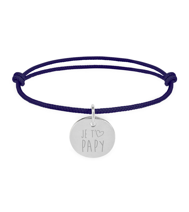 Un bracelet en argent avec une médaille de 15mm, portant un cordon bleu marine.
