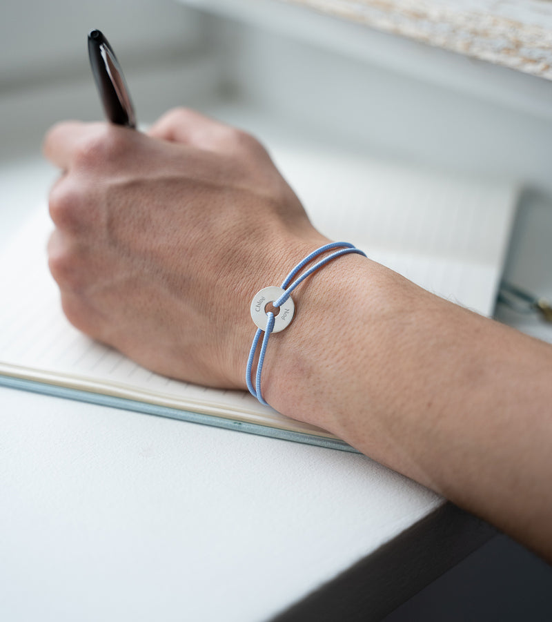 Un bracelet en forme de cible, personnalisé de 15mm en argent, avec un cordon bleu pastel.