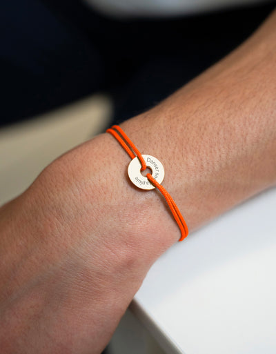 Un bracelet en forme de cible, personnalisé en 15mm, plaqué or, avec un cordon orange fluo