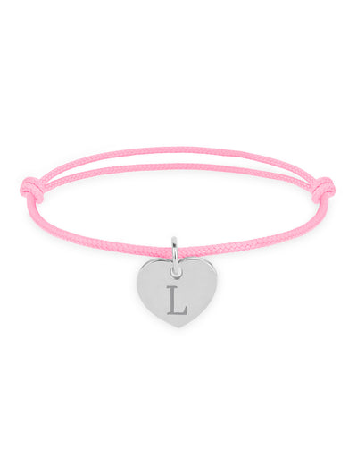 Le bracelet présente un cœur argenté de 15mm, monté sur un cordon rose.