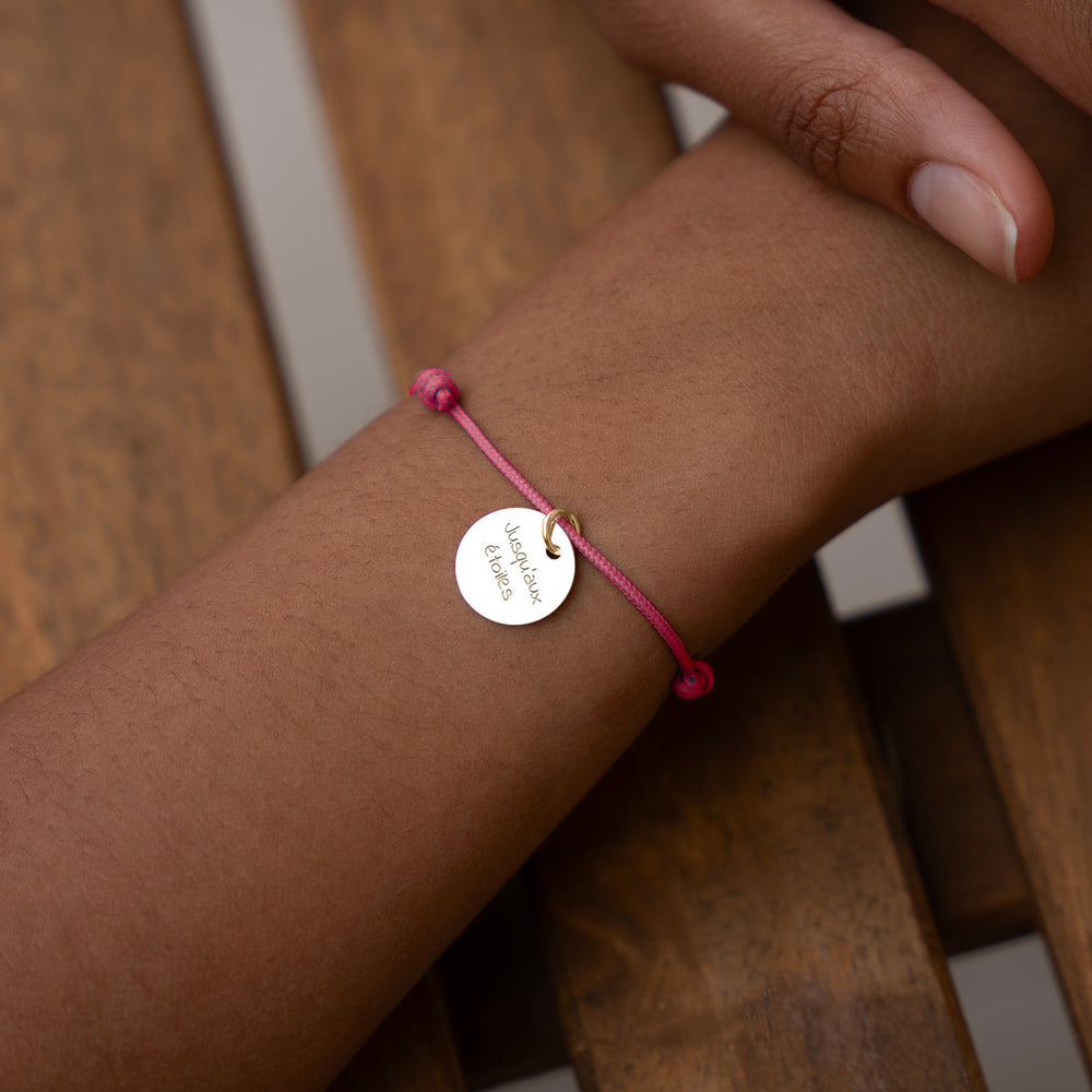 Un accessoire de mode élégant, avec une médaille de 15mm plaqué or, accompagné d'un cordon rose fuchsia.