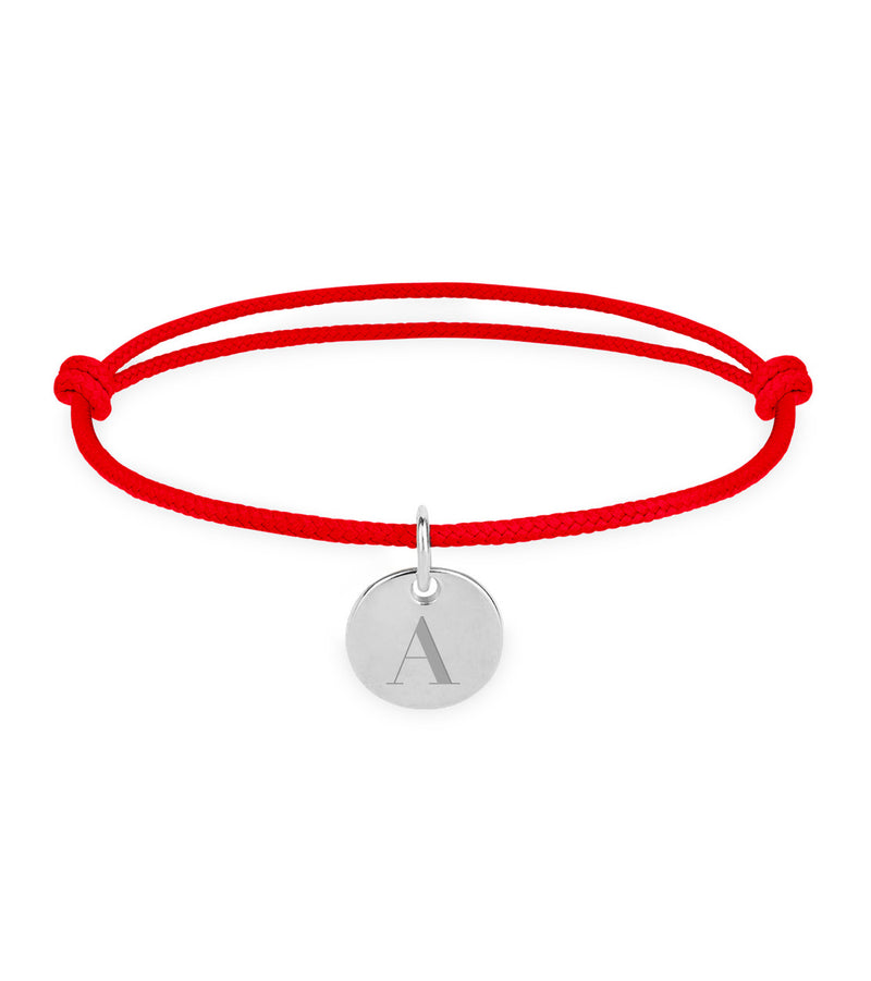 Un bracelet personnalisé en argent, avec une médaille de 10mm et un cordon rouge.