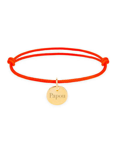 Une médaille dorée brillante suspendue à un cordon orange fluo.