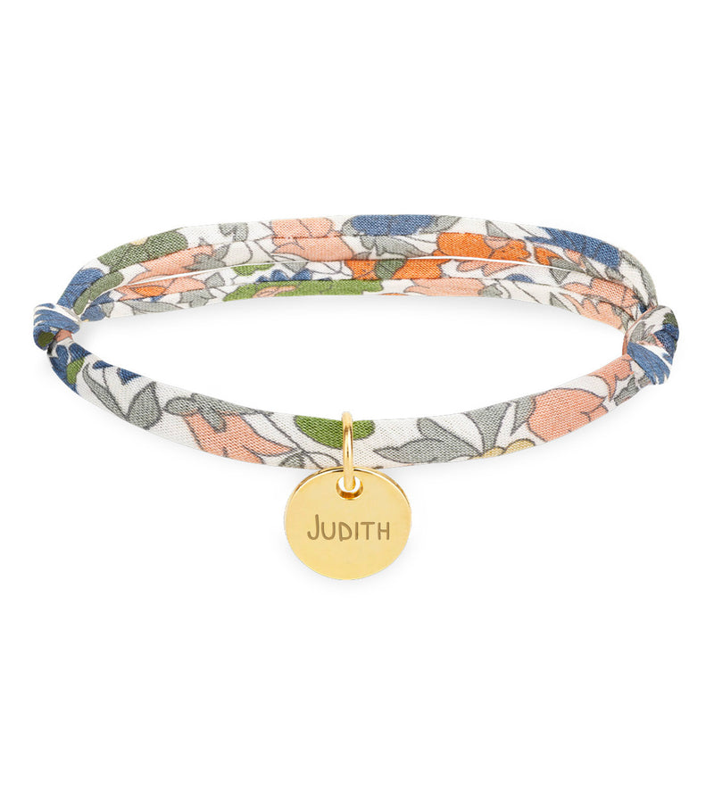 Un bracelet personnalisé avec une médaille de 10mm en plaqué or, agrémenté d'un lien Liberty lilas.