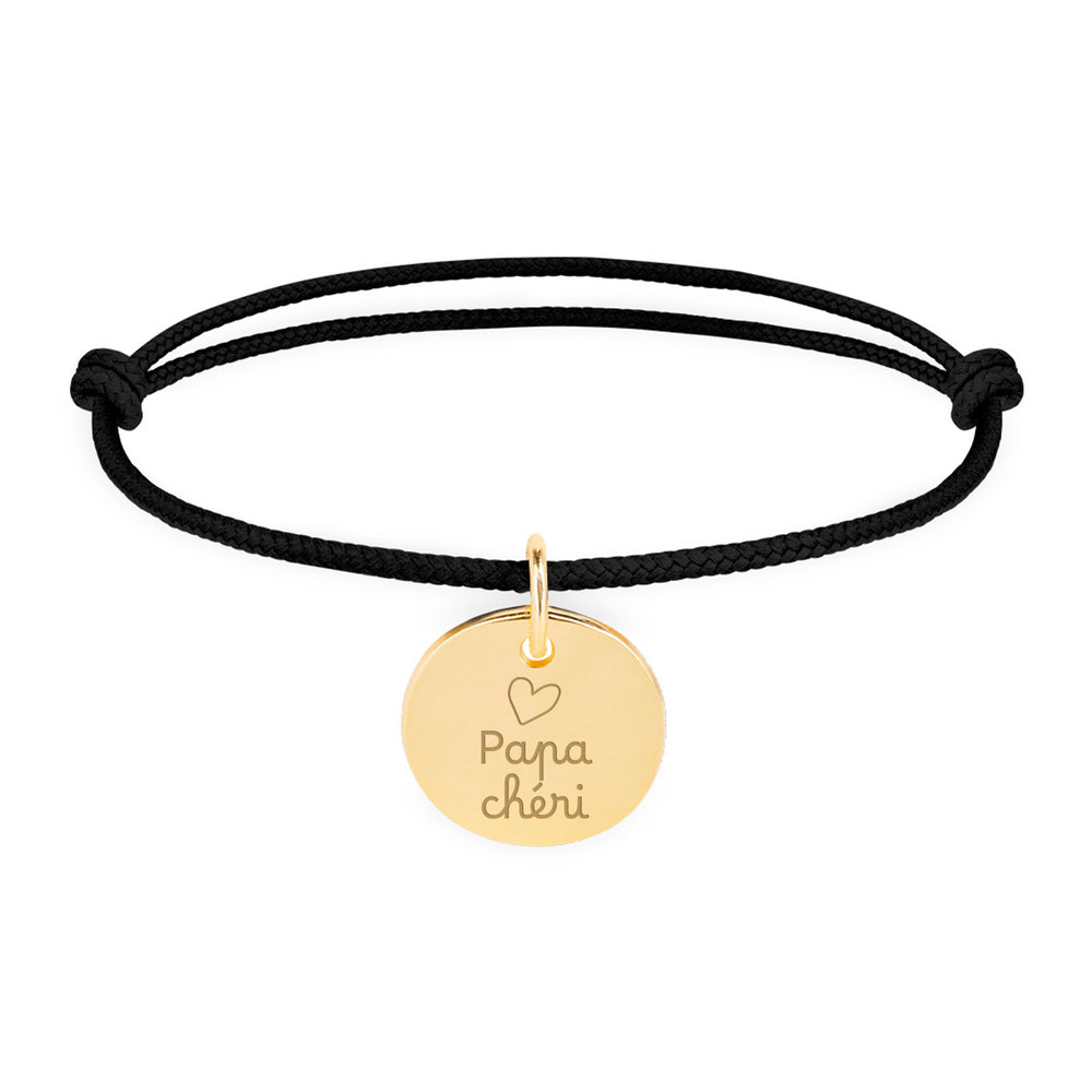 Un bracelet personnalisé en plaqué or, avec une médaille de 15mm, sur cordon noir.