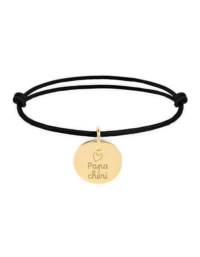 Un bracelet personnalisé en plaqué or, avec une médaille de 15mm, sur cordon noir.