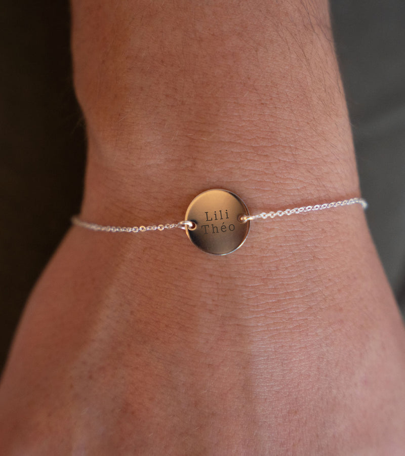 Une médaille de 15mm personnalisée, montée sur un bracelet en argent, dont la chaîne plate assure un ajustement confortable ainsi qu'une fixation avec ses deux trous.