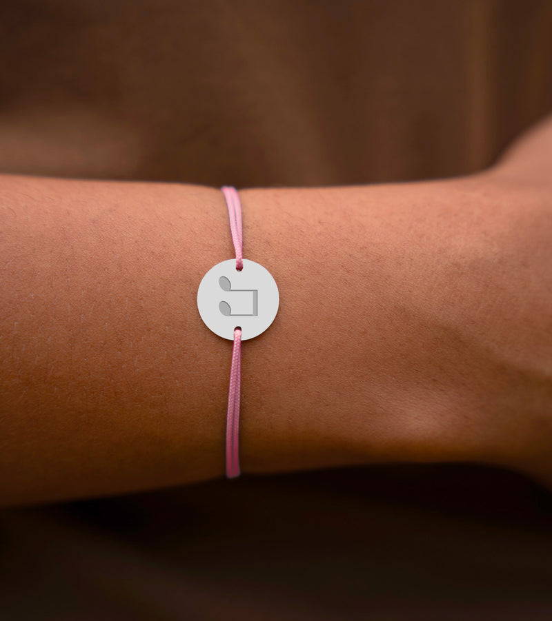 Un bracelet argenté étincelant, agrémenté d'une médaille de 15mm personnalisée dotée de 2 trous, assorti d'un cordon rose élégant