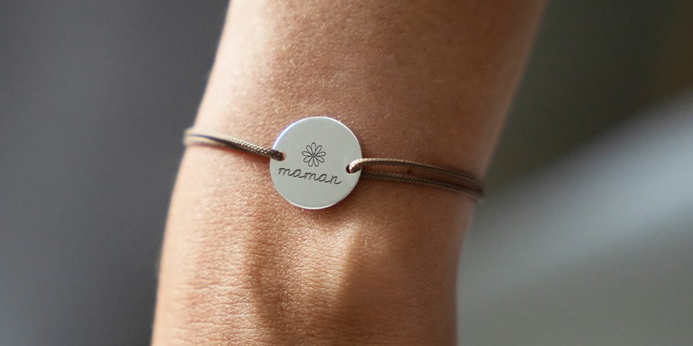 Bracelet argenté doté d'une médaille de 15mm personnalisée à deux trous et d'un cordon marron clair.