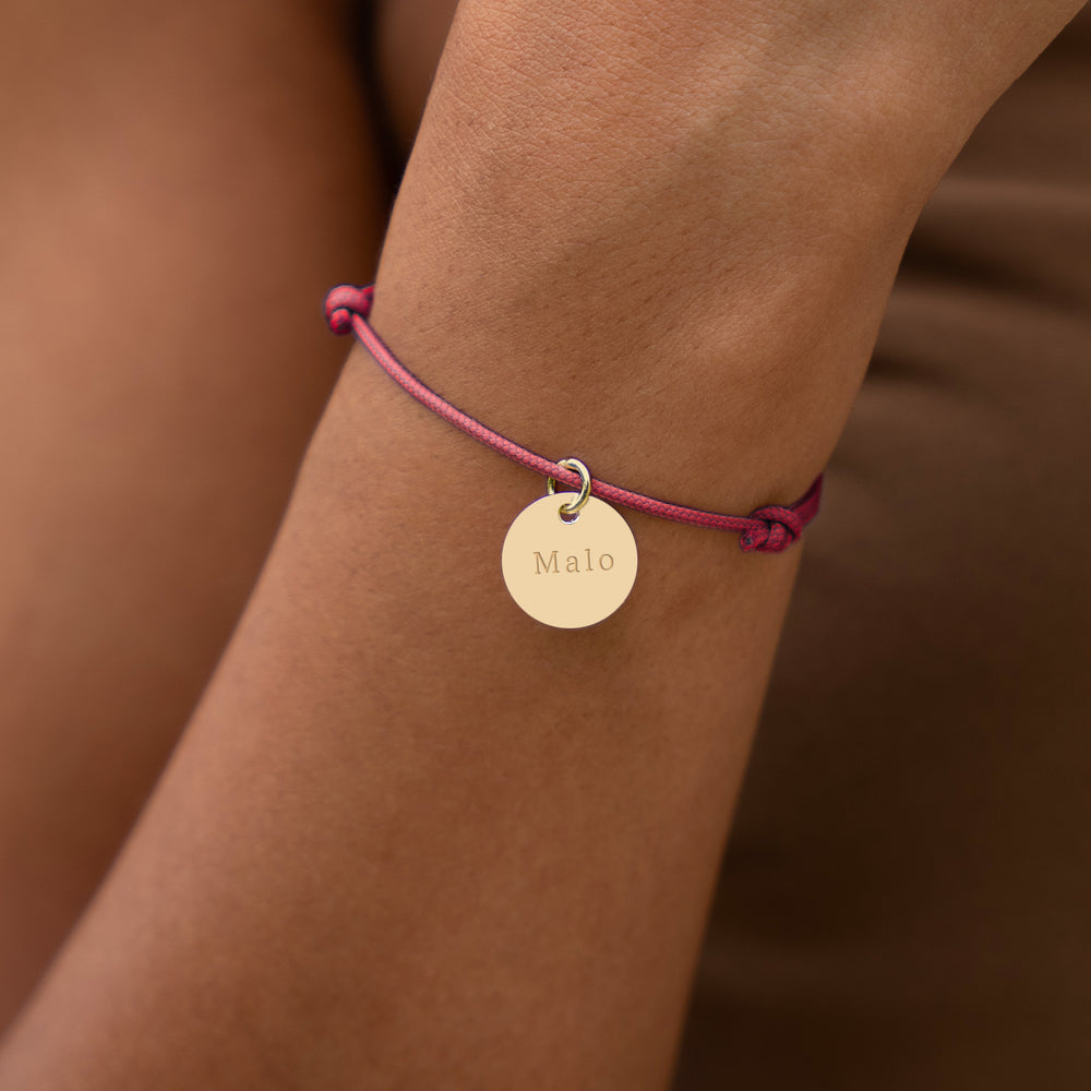 Un bijou raffiné, avec une médaille de 15mm en plaqué or, assorti d'un cordon rose fuchsia.